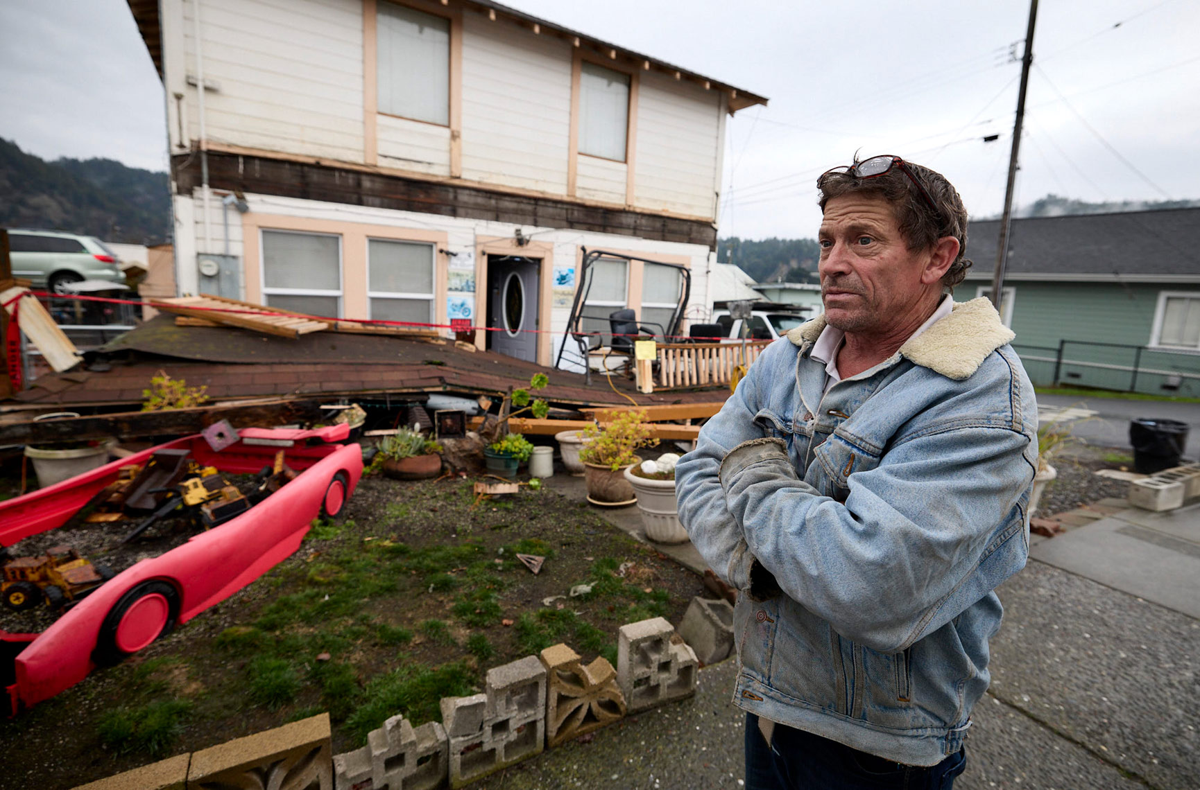 Man Stands In Front Of His Earthquake Damaged Home