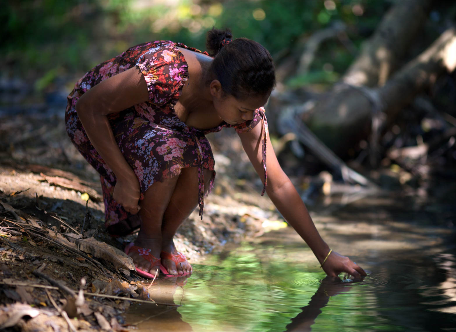 Woman Drinking Water from Stream