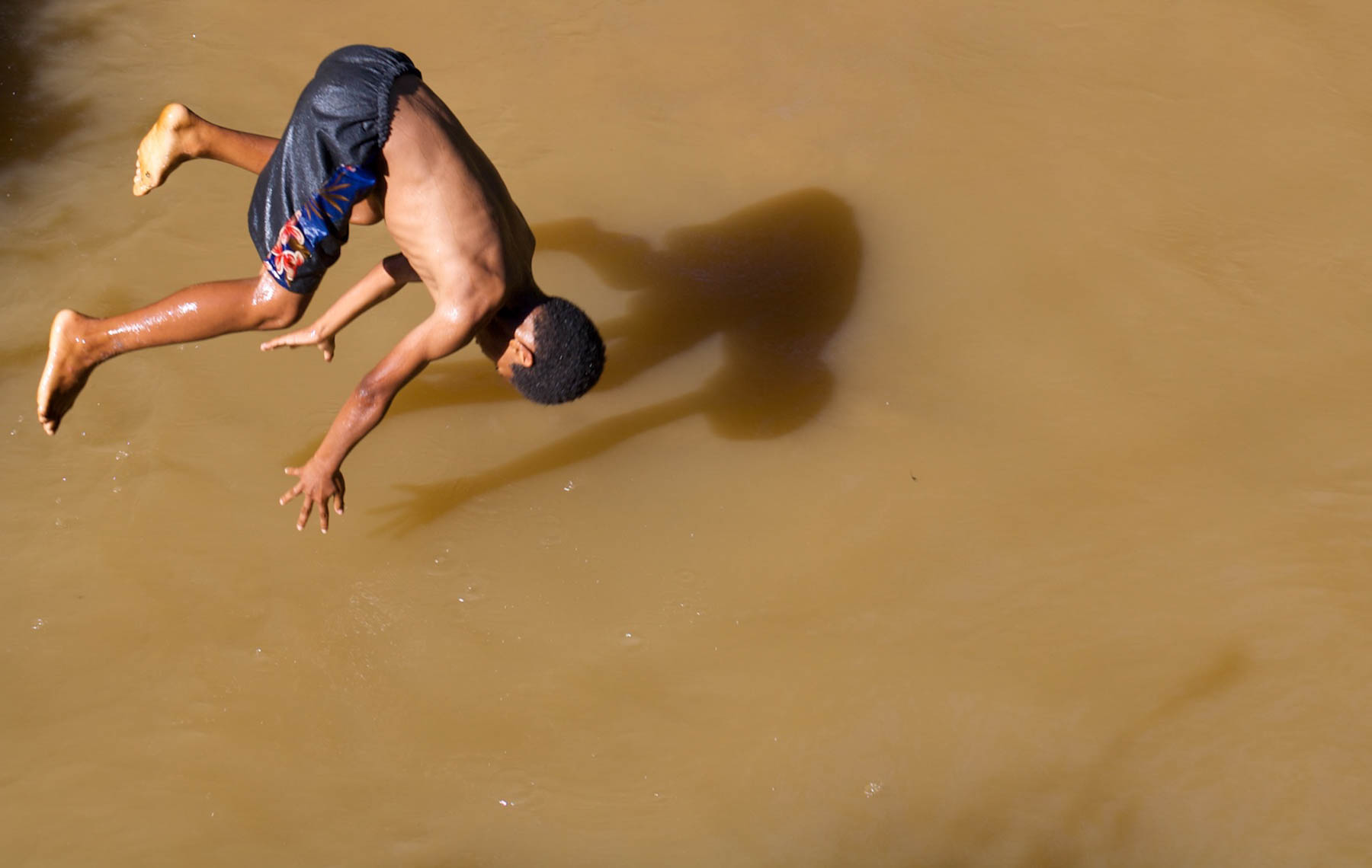 Kid Diving in to Muddy Water in Fiji