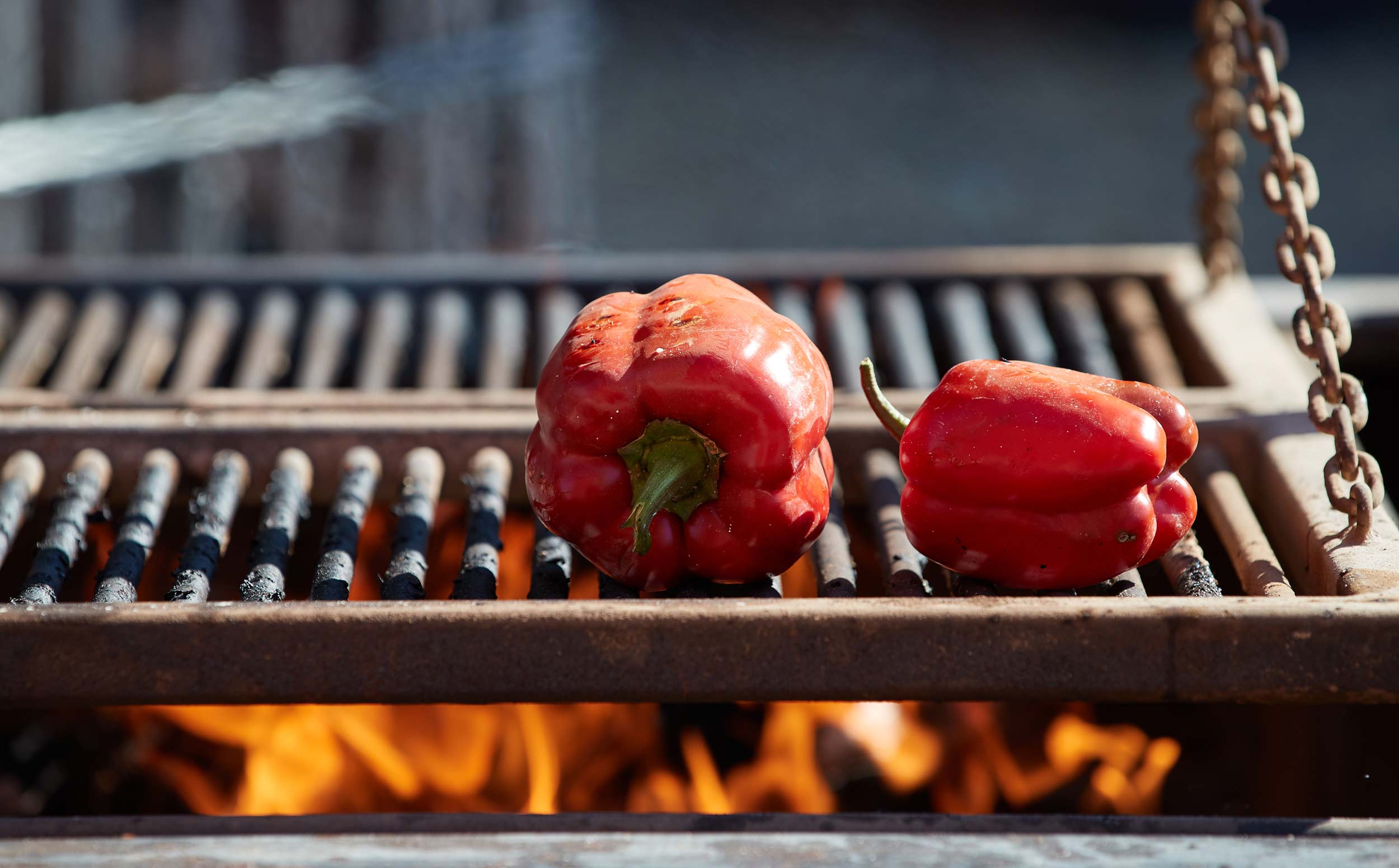 Red Peppers Grill Over an Open Flame