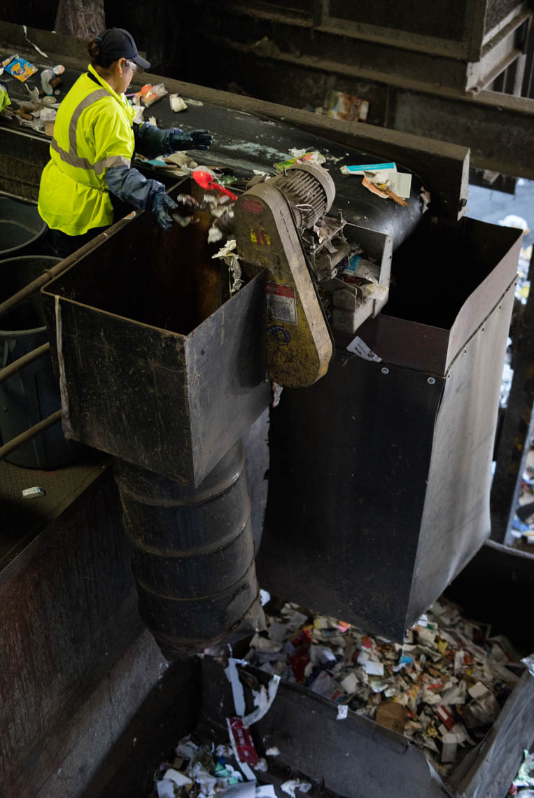 A Worker Sorts Items to Recycle