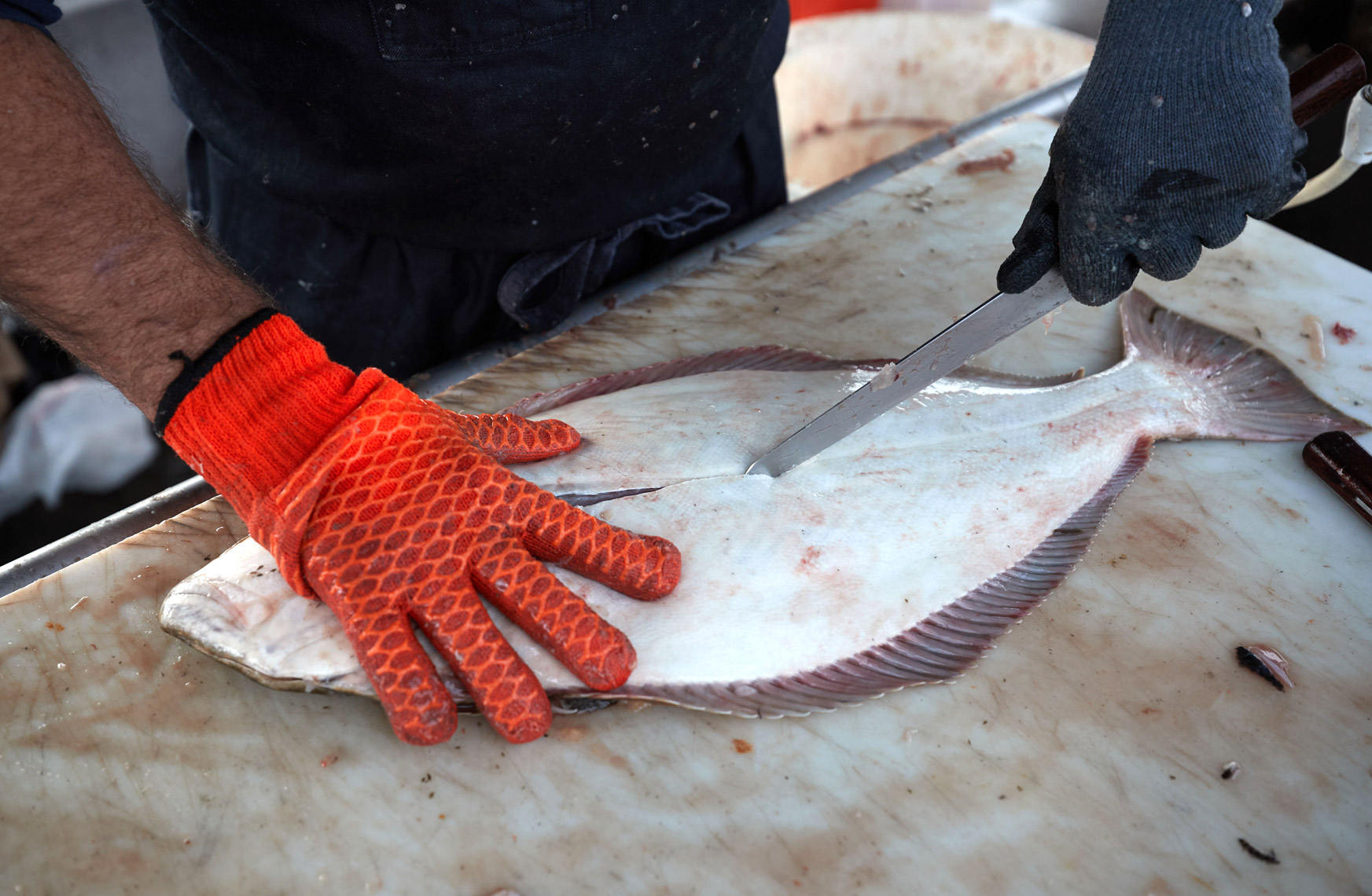 Cutting Station Worker Prepares Halibut for a Customer