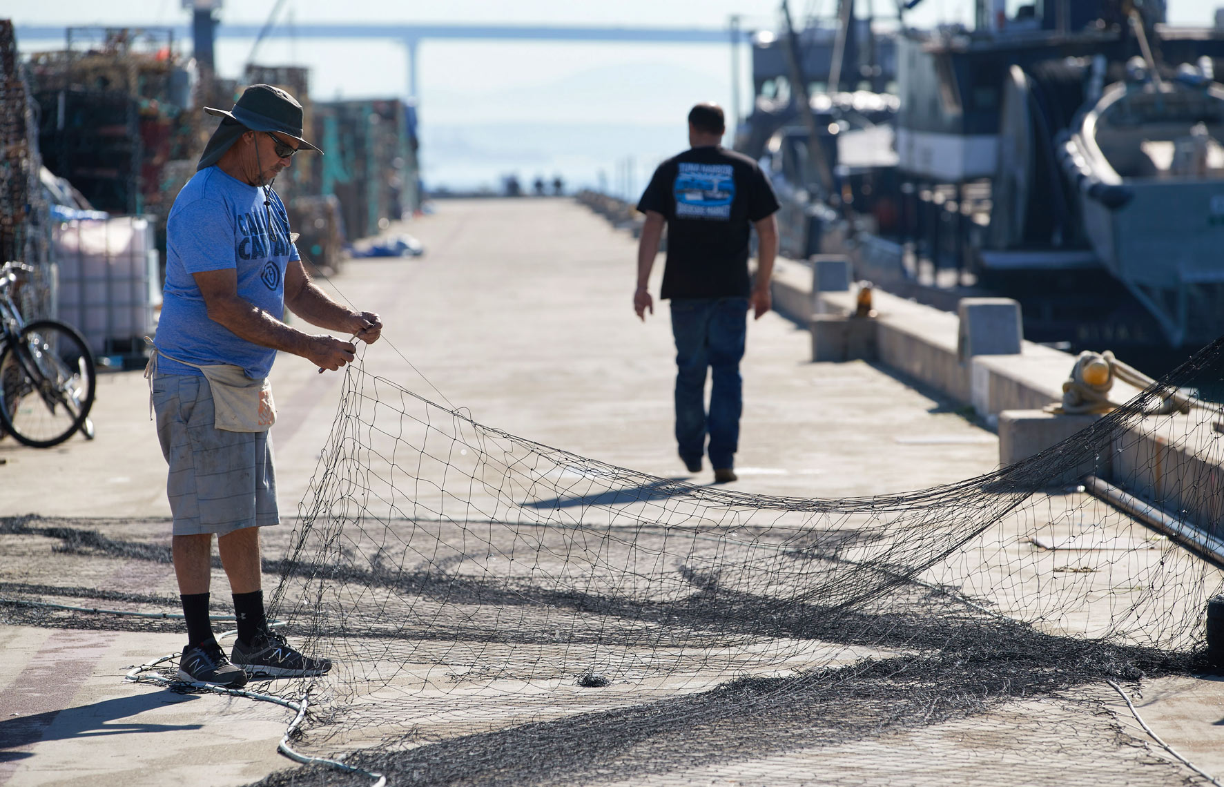 A Worker Repairs Fishing Nets on a Dock in San Diego